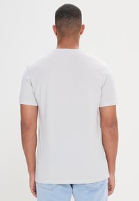 Korte mouwen, lichtgrijze t-shirt met een textuurpatroon. Ronde hals, rechte zoom en een relaxte pasvorm. Standaard stof en casual ontwerp.