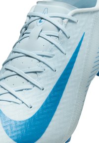 Heledad sinine jalgpalliking, millel on tekstureeritud pind, silmapaistev sinine Nike swoosh ja keeruline sidumis süsteem toe tagamiseks.