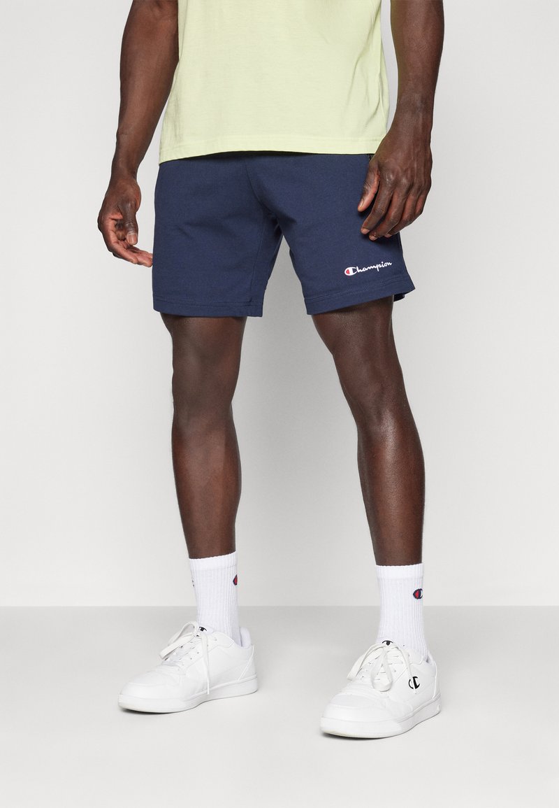 Navy blue Champion shorts in a cotton blend with an elastic waistband, side pockets, and embroidered logo on the left side.