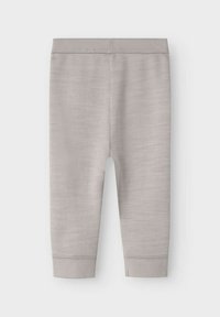 Ljusgrå leggings i ett mjukt, elastiskt material. De har en åtsittande design med en slät midja och fållade muddar.