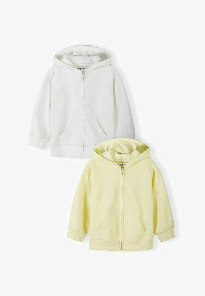 Deux sweat-shirts à capuche zippés pour enfants, l'un en blanc et l'autre en jaune pâle, tous deux avec des poches avant et des poignets côtelés.