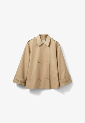 Trench-coat beige à double boutonnage avec un large col, des épaulettes, de gros boutons et des sangles aux poignets. Fabriqué dans un tissu lisse et léger.