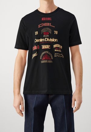 Mężczyzna noszący czarny T-shirt z krótkim rękawem z różnymi logo i tekstami Diesel, w tym "Denim Division" i "Successful Living Since 1978."