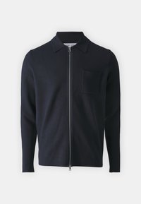 Veste noire à manches longues avec fermeture éclair, col et poche poitrine gauche, présentée sur fond blanc.
