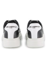 Παιδικά αθλητικά παπούτσια σε ασπρόμαυρο, με μαλακό δερμάτινο επάνω μέρος, επενδυμένο γιακά και λευκή λαστιχένια σόλα. Σήμανση στο πίσω μέρος.