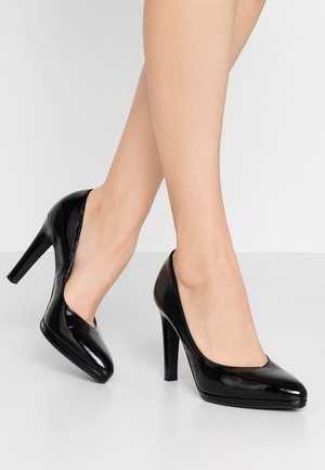 Czarne lakierowane szpilki z eleganckim, spiczastym noskiem i 10 cm obcasem w szpilkę. Gładka powierzchnia i minimalistyczny design podkreślają elegancję.