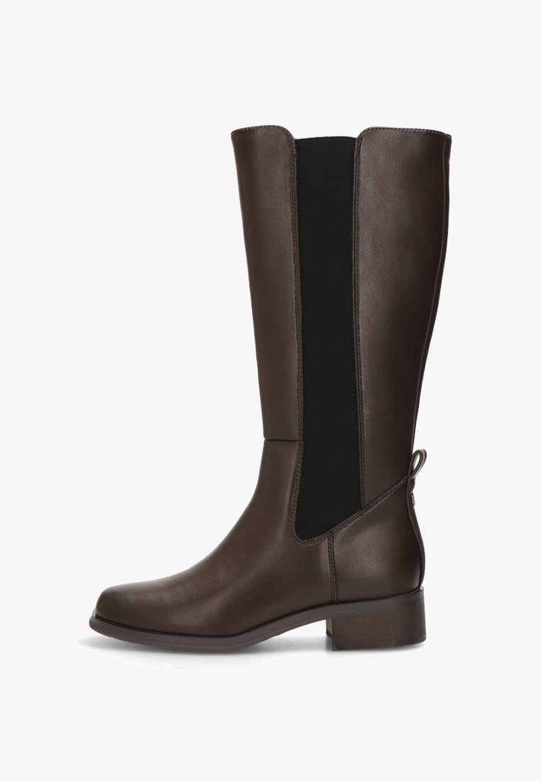 Bota de cuero marrón hasta la rodilla con un diseño elegante, paneles texturizados, inserciones laterales elásticas y un tacón pequeño. Detalle de lazo notable en la parte trasera.