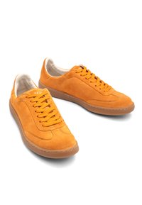 Pomarańczowe zamszowe sneakersy z okrągłym noskiem, systemem sznurowania i teksturowaną gumową podeszwą. Posiadają przyszywane akcenty oraz miękką beżową podszewkę.