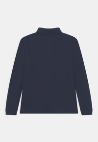 Mörkblå långärmad polo med krage och ribbade ärmslut. Slät textur och enkelt design, inga synliga logotyper eller mönster.