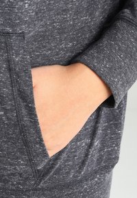 Donkergrijze hoodie van een gestructureerde, gemarmerde stof. Voorzien van een kangoeroe-pocket, ribgebreide boorden en een ontspannen pasvorm.