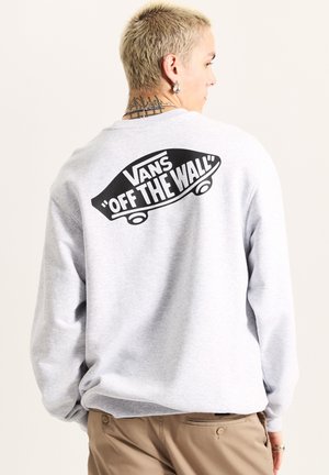 Grijze sweater met een ronde halslijn en lange mouwen. Heeft een grote zwarte grafiek van een skateboard en de tekst "VANS 'OFF THE WALL'" op de achterkant.