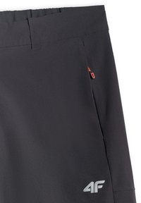 Shorts de sport noirs avec taille élastique, poche zippée latérale avec languette rouge et logo 4F réfléchissant près de l'ourlet.