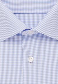 Camicia a scacchi blu e bianchi con colletto alla francese e un bottone bianco sul davanti, realizzata in un tessuto liscio.