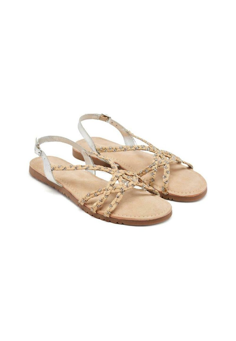 Sandalias planas beige con tiras trenzadas, detalles en plata y una suela acolchada. Presenta un diseño minimalista y correas ajustables en los tobillos.
