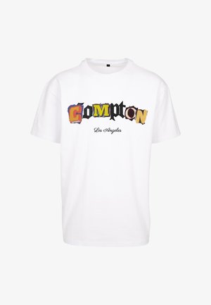 Bela bomba majica iz bombaža z napisom "Compton" v pisanih, raznolikih pisavah in "Los Angeles" v manjšem, kurzivnem stilu spodaj. Kratki rokavi.