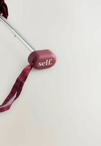 Laska do chodzenia z burgundowym gumowym uchwytem, na którym znajduje się słowo "self." w białym kolorze. Przypięta jest pasująca burgundowa tasiemka satynowa.
