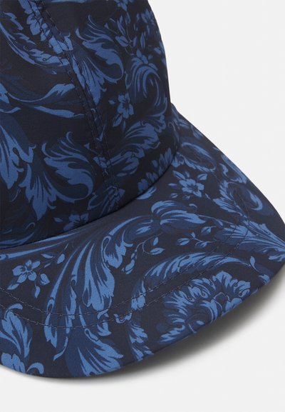 Σκούρο μπλε καπέλο με floral σχέδιο σε διάφορες αποχρώσεις του μπλε, κατασκευασμένο από απαλό ύφασμα με ορατές λεπτομέρειες ραφής.