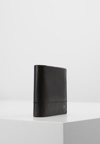 Portefeuille en cuir noir au design minimaliste, avec une texture lisse, des détails cousus et un petit logo en relief sur le côté.