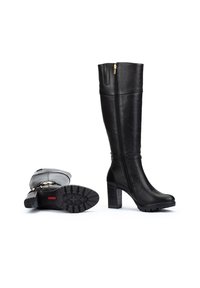 Botas negras hasta la rodilla fabricadas en cuero liso. Cuentan con una cremallera lateral, tacón grueso y suela resistente con un patrón texturizado.