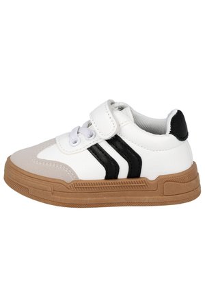 Zapatilla blanca para niños con suela marrón claro, rayas negras en el lateral, cordones blancos y una tira blanca de velcro, mostrada desde el perfil exterior.
