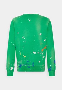Vihreä crewneck-huppari pitkillä hihoilla ja monivärinen maali-roiske kuvio selässä ja hihoissa.