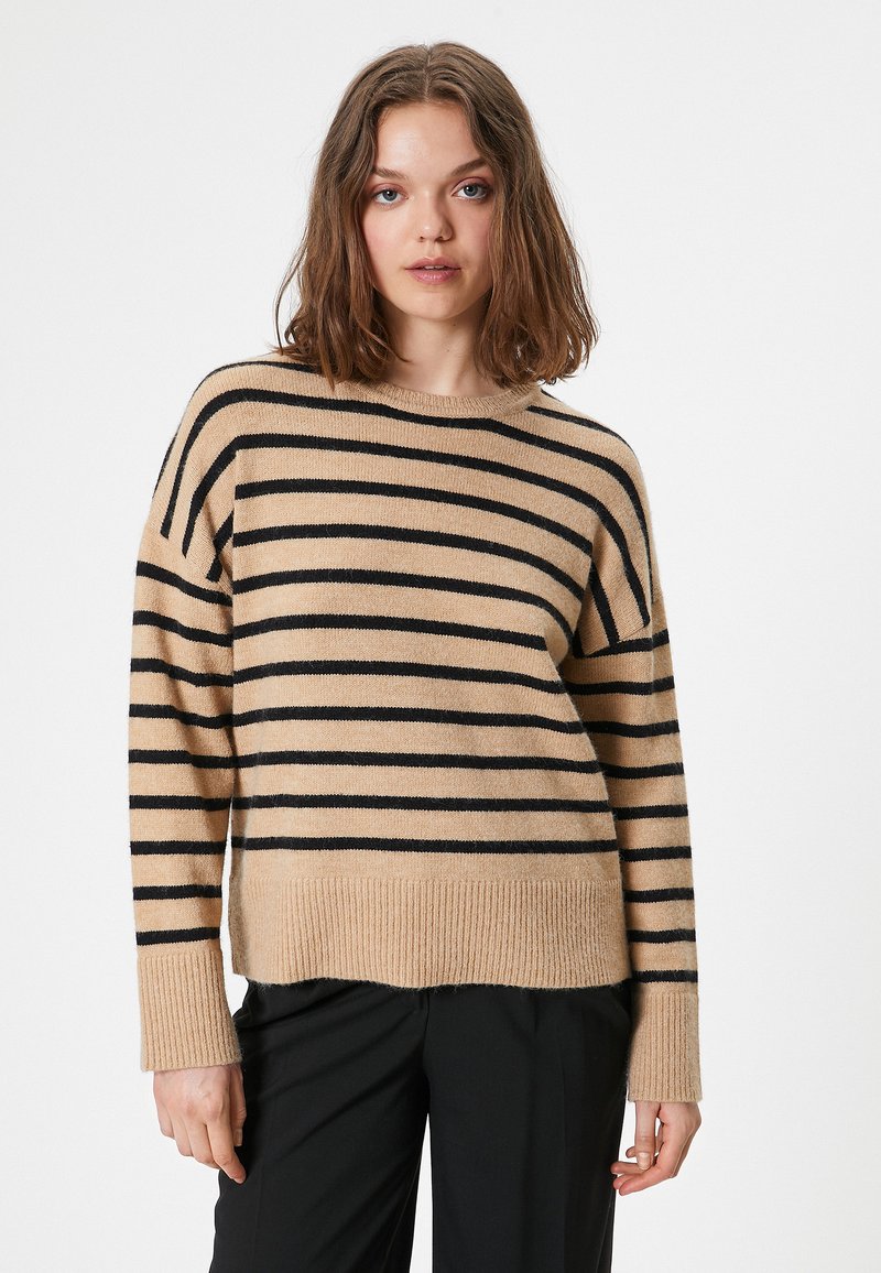 Maglione beige a righe con righe orizzontali nere, maniche lunghe, collo e polsini a costine e vestibilità rilassata.