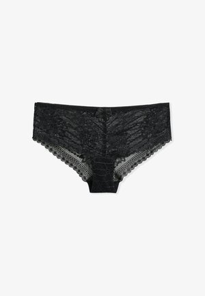 Slip hipster in pizzo nero con motivo floreale, bordi smerlati e un piccolo fiocco al centro della cintura, su sfondo bianco.