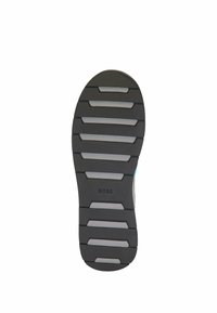 Semelle de chaussure en caoutchouc noir avec des rainures horizontales et une texture en relief, ornée d'une bande grise et du logo "BOSS" embossé près du centre.