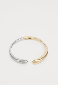 Pulseira de pulso em prata e ouro bicolor, com extremidades suaves e arredondadas, apresentando um design minimalista com um acabamento polido. Marca gravada por dentro.