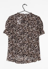 Blouse transparente avec un col rond, des manches courtes bouffantes et un ourlet à volants. Présente un motif floral abstrait marron et beige.