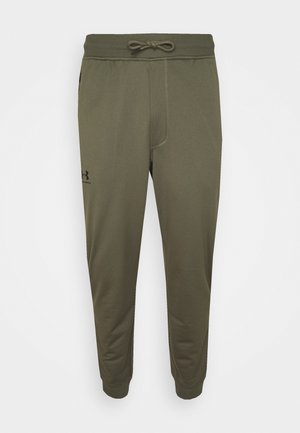 Olijfgroene joggingbroek met een elastische tailleband, trekkoord, taps toelopende pijpen en zijzakken. Heeft een klein zwart logo op het linkerpakket.