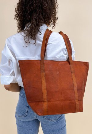 Braune Ledertasche im strukturierten rechteckigen Design, mit längeren Trägern, kontrastierenden Nähten und einer glatten, polierten Oberfläche.