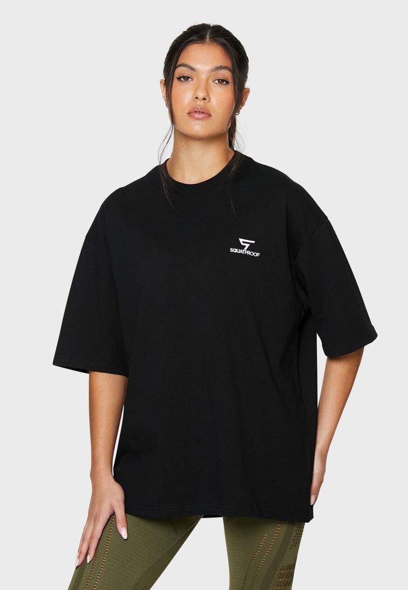 Sort oversized t-shirt lavet af bomuld, med et lille hvidt "SQUATPROOF" logo på brystet. Korte ærmer, afslappet pasform.