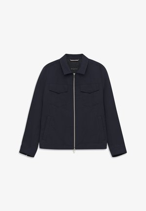 Marineblaue Herrenjacke mit Reißverschluss, spitzem Kragen, zwei Brustklappentaschen und zwei Seitentaschen, flach auf weißem Hintergrund liegend.