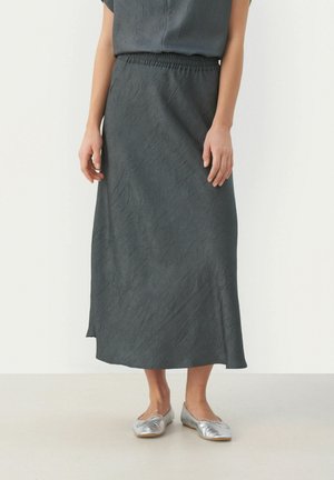 Grijze midi-rok van textuurstof, met een elastische tailleband. Gekoeld met glanzende zilveren platte schoenen.