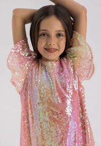 Robe à manches courtes avec un col rond, ornée de paillettes roses étincelantes, de manches en voile bouffantes et d'un doublage rose lisse en dessous.
