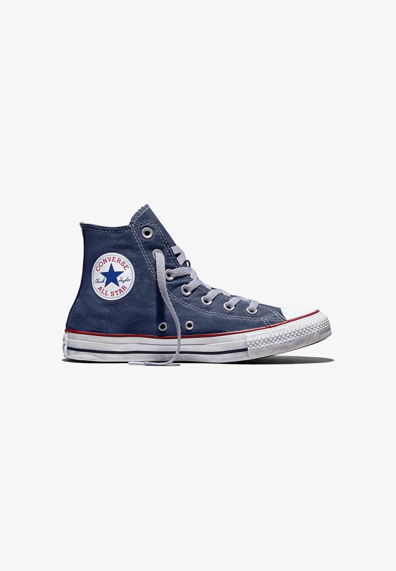 Zapatilla Converse Chuck Taylor All Star de caña alta en azul marino, con suela de goma blanca, puntera y cordones blancos, vista de lado sobre fondo blanco.