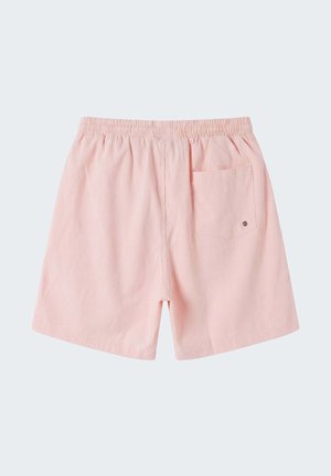 Shorts à taille élastique rose clair avec une poche arrière unique ornée d'un petit bouton métallique.