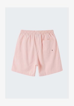Shorts à taille élastique rose clair avec une poche arrière unique ornée d'un petit bouton métallique.