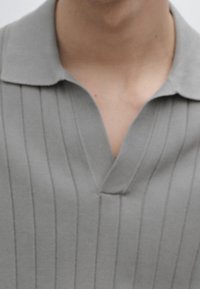 Gray polo shirt featuring vertical ribbed texture, a V-neck collar, and a relaxed fit, made from a soft, lightweight material.