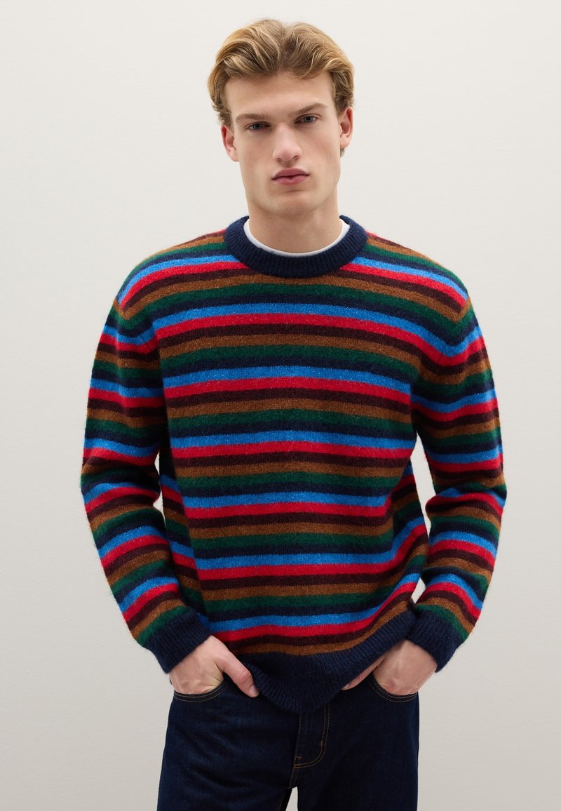 Multicolored striped sweater with a round neckline. Features red, blue, green, and brown stripes. Soft texture with ribbed cuffs and hem.