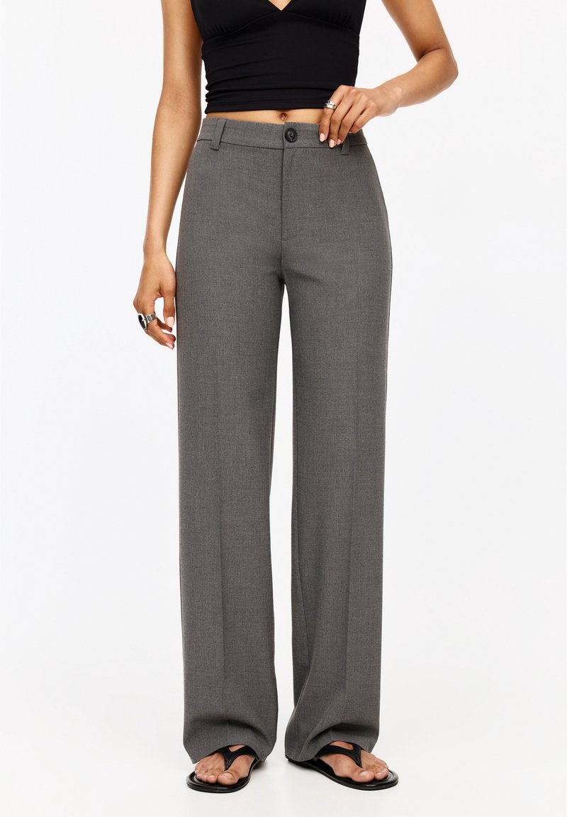 Hoge taille, wijde broek van textuur grijs stof met een platte voorkant en een enkele knoopsluiting. Gepaarde met een zwart cropped top.