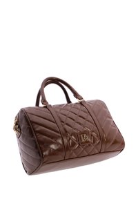 Bolso de cuero marrón brillante con patrón acolchado, doble asa y una placa de logo dorada en la parte frontal.