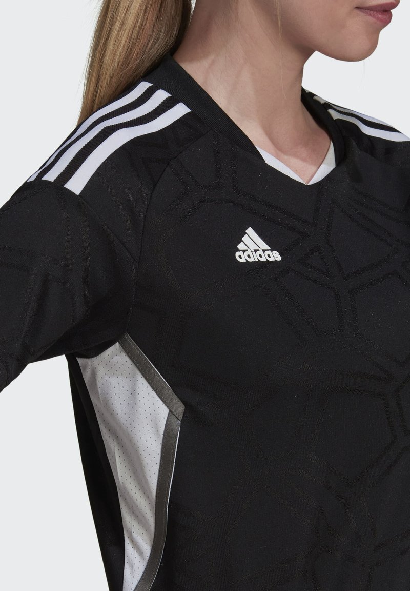 Camiseta atlética negra con un patrón hexagonal texturizado, paneles laterales de malla blanca, acentos plateados y el logo de Adidas en el pecho.