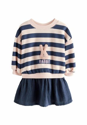Enfant portant un pull rayé beige et bleu marine avec un visage de lapin en peluche et le texte "RABBIT", assorti à une jupe texturée bleu marine.