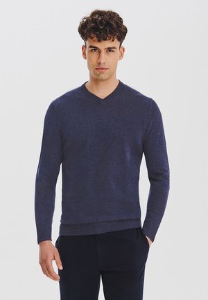 Granatowy sweter z dekoltem w serek, wykonany z miękkiej dzianiny. Posiada długie rękawy oraz ściągacze na mankietach i dole. Prosty, bezszwowy design bez wzorów.