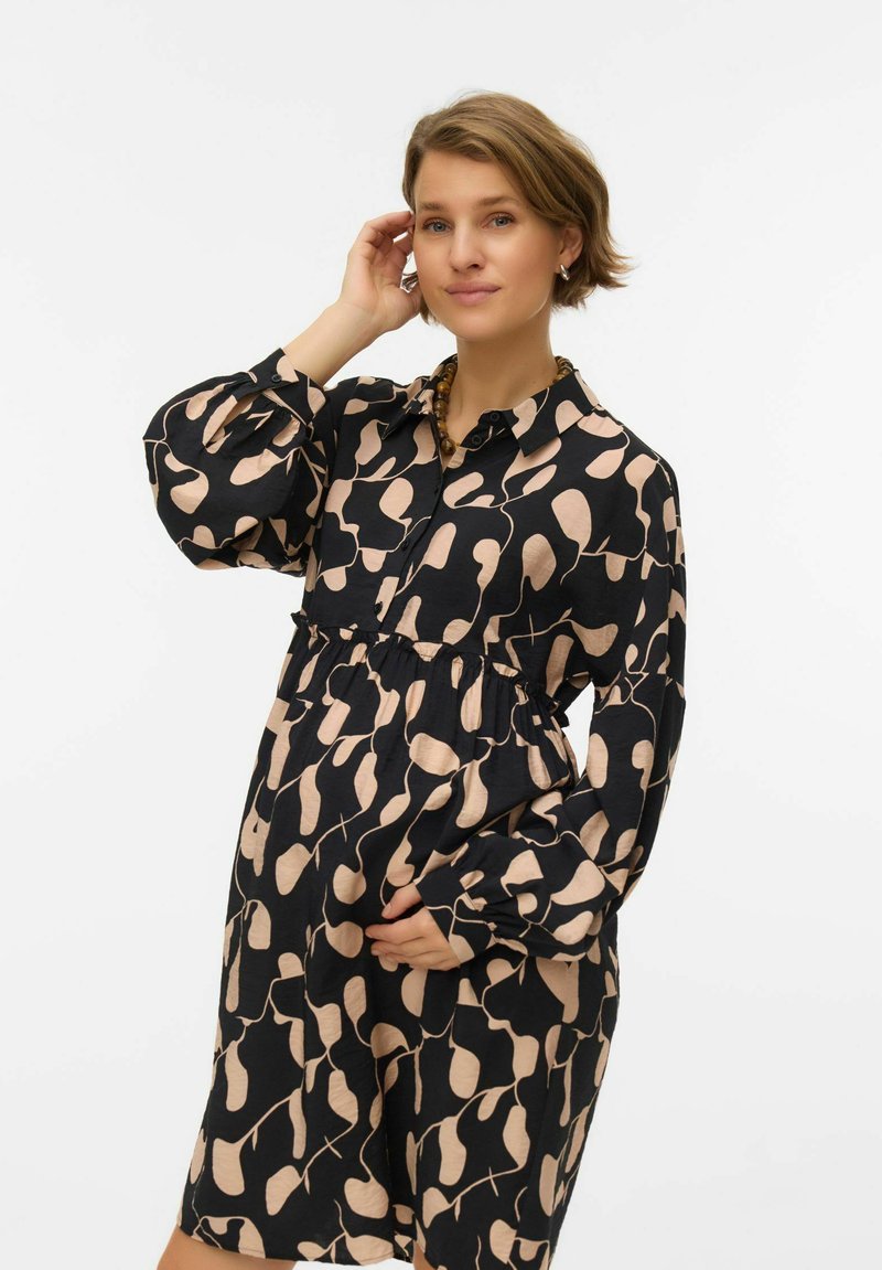 Czarna sukienka z beżowym abstrakcyjnym wzorem, kołnierzykiem na guziki, długimi rękawami i dopasowaną talią. Miękka tkanina o zwiewnym kroju.