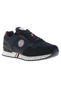 Marine sneaker met bovenwerk van mesh en suede, witte en rode accenten, gestructureerde tussenzool met spikkels, zwarte rubberen buitenzool, ronde logo detail.