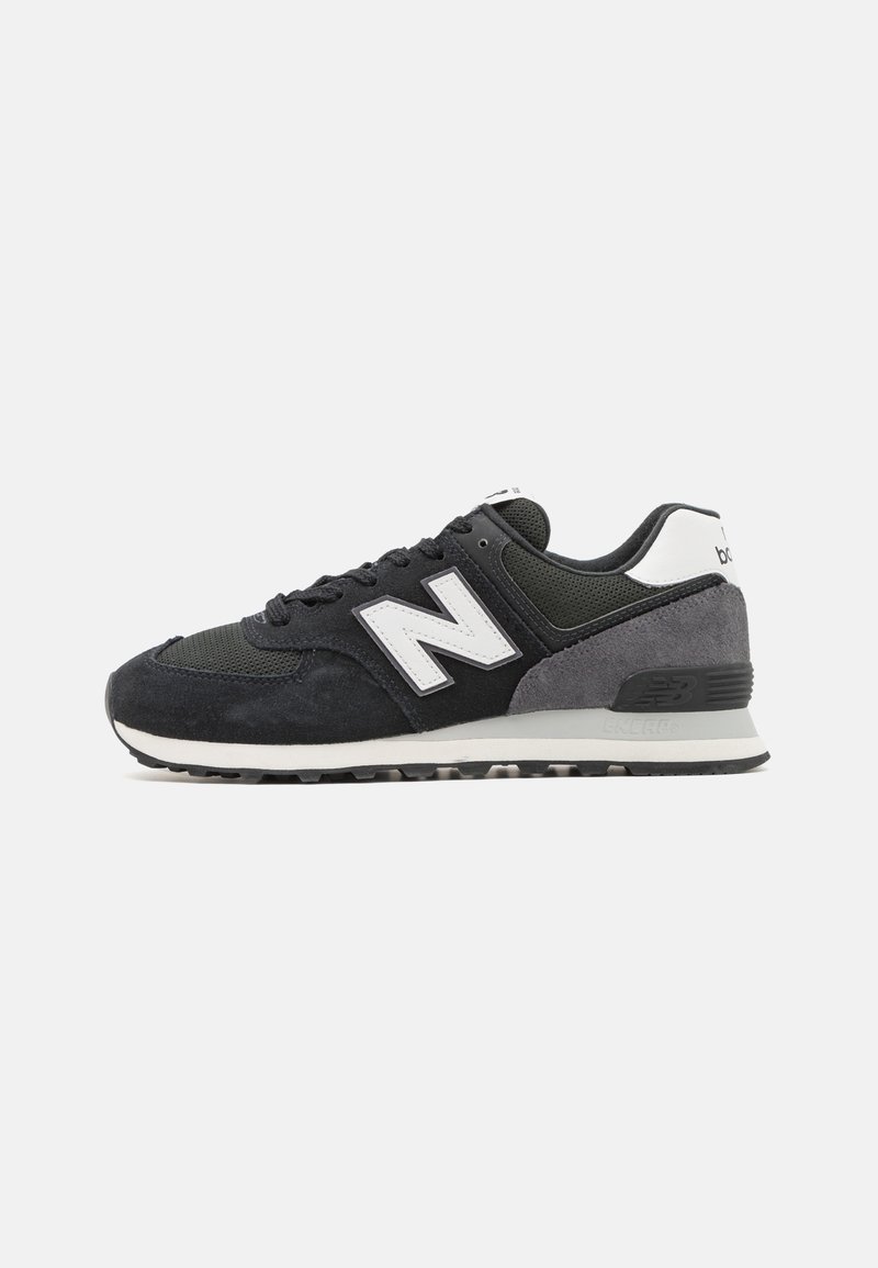 Baskets New Balance noires et grises avec logo "N" blanc, languette de talon blanche et semelle rembourrée, vues de côté droit sur fond blanc.
