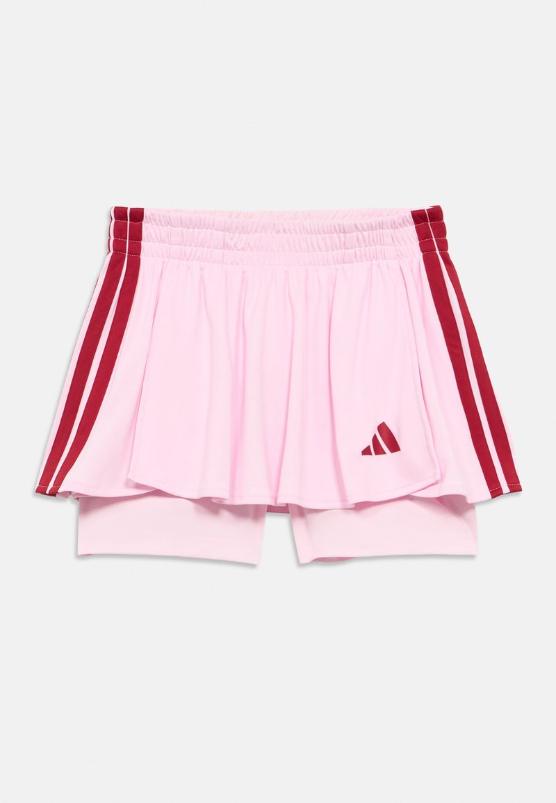 Rózsaszín sport szoknya beépített rövidnadrággal, piros oldalsávokkal és elől háromszög logóval. Rugalmas derékrész a kényelemért.